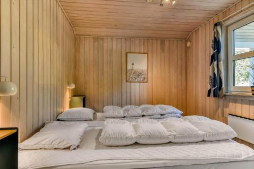 a bedroom with four beds in a room with wooden walls at BV267-Blavand-Karl-Postsvej-5 in Blåvand
