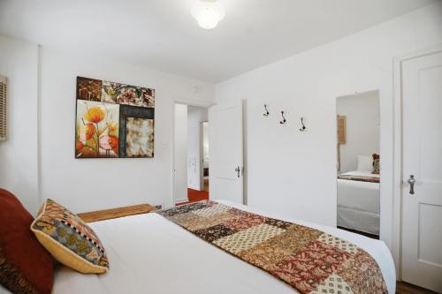 a white bedroom with a bed and a painting on the wall at Como Classic in Saint Paul