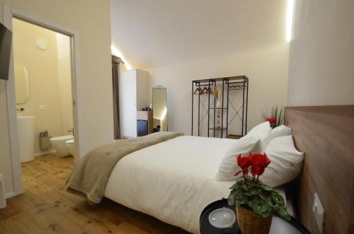 a bedroom with a large white bed and a bathroom at Il Cortile del Principe in Castel di Sangro