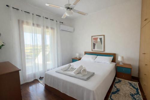a bedroom with a bed with two towels on it at Villa Erato Keratea in Keratea