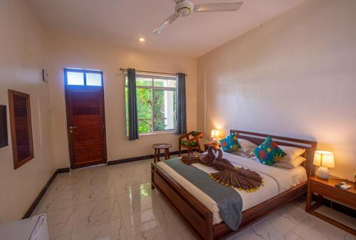 a bedroom with a large bed and a window at Double A Nungwi Beach Hotel - Beach Front in Nungwi