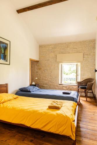 a bedroom with a bed with yellow sheets and a window at Le Pistoulet Gîte in Doeuil-sur-le-Mignon