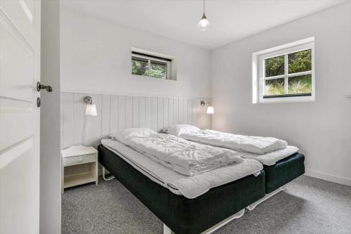 a bed in a white room with two windows at BV374-Blavand-Krogsande-22 in Blåvand