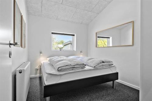 a white bedroom with a bed with a mirror at BV144-Blavand-Horntoftvej-13 in Blåvand