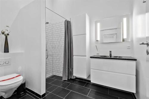 a white bathroom with a toilet and a sink at BV144-Blavand-Horntoftvej-13 in Blåvand