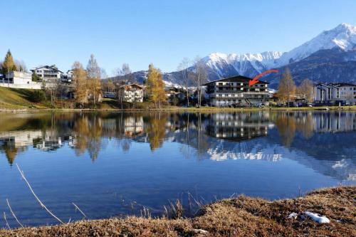 a lake with houses and mountains in the background at La Riva mit Berg- und Seeblick in Laax