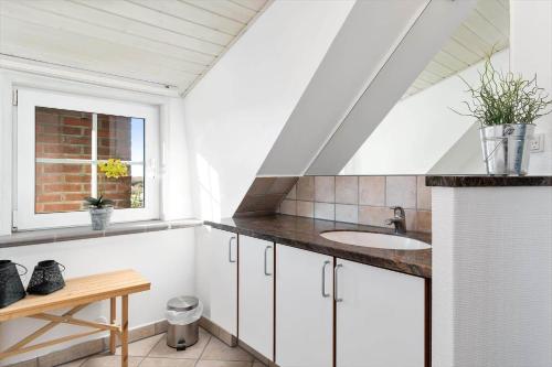 a white bathroom with a sink and a window at BV277-Blavand-Klitvej-4 in Blåvand