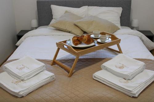 a table with a plate of food on a bed at Square Garden apartment in Novi Sad