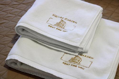 a pile of towels sitting on top of a bed at Square Garden apartment in Novi Sad