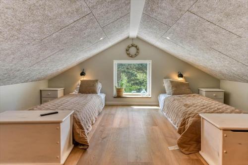 a attic bedroom with two beds and a window at BV234-Blavand-Pouls-Bjerge-14 in Blåvand