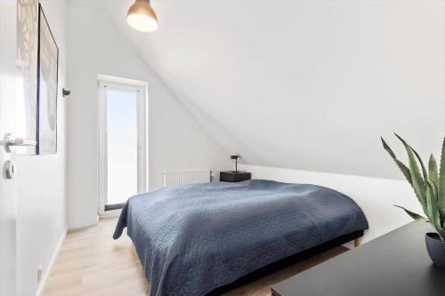 a white bedroom with a bed and a window at BV100-Blavand-Blavandvej-53-C in Blåvand