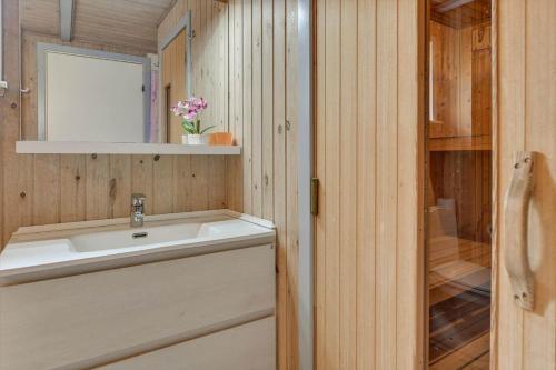 a bathroom with a sink and a mirror at BV348-Blavand-Fyrgarden-19 in Blåvand