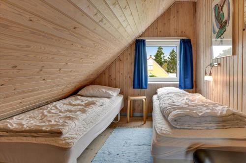 two beds in a room with a window at BV348-Blavand-Fyrgarden-19 in Blåvand
