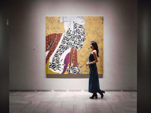 a woman is standing in front of a painting at Pullman Tokyo Tamachi in Tokyo