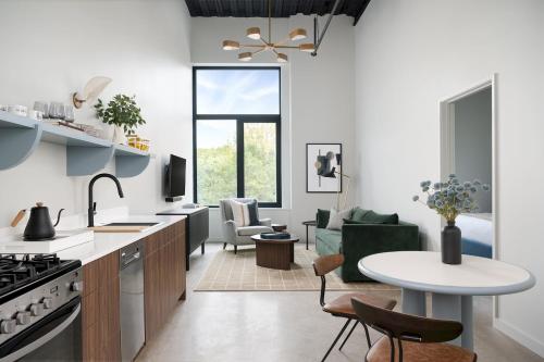 an open kitchen and living room with a table at The Neighborhood Hotel - Little Italy Studio in Chicago