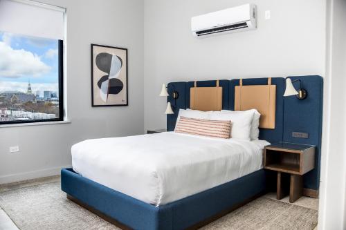 a bedroom with a blue and white bed and a window at The Neighborhood Hotel - Little Italy Studio in Chicago