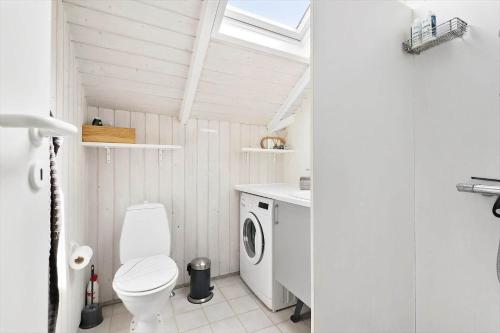 a bathroom with a toilet and a washing machine at BV366-Blavand-Skaubjergvej-4 in Blåvand