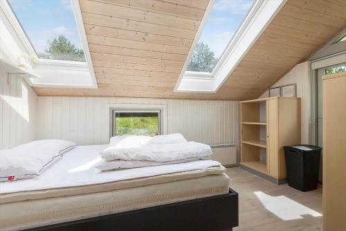 a bedroom with two beds in a room with skylights at BV366-Blavand-Skaubjergvej-4 in Blåvand