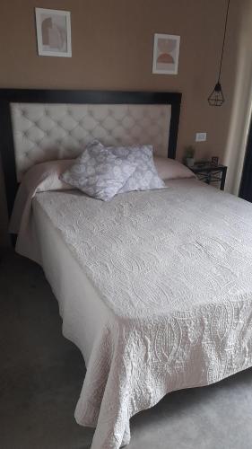 a white bed with a white comforter on it at La Su in Duggan