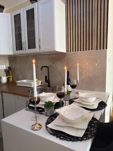a kitchen with a table with white plates and candles at Grand Line in Sombor