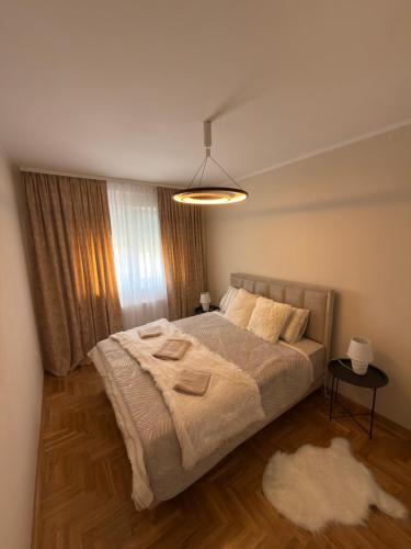 a bedroom with a large bed and a lamp at Grand Line in Sombor