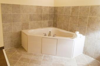 a bathroom with a bath tub in a room at Garden Inn Hotel in Union City