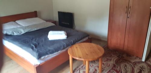 a bedroom with a bed with a table and a stool at LeśnyZakątekNysa in Skorochow