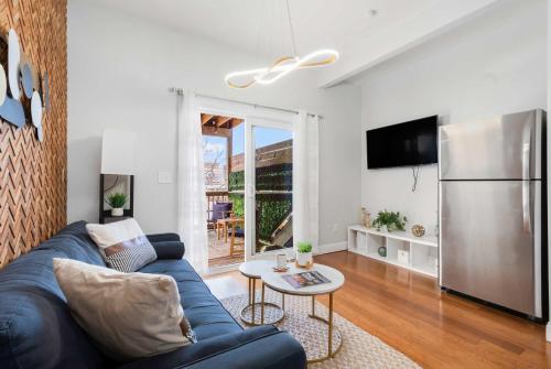 a living room with a blue couch and a refrigerator at Jennifer's Chic 2nd Floor Apt Private Deck w Views in Providence