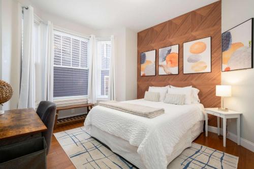 a bedroom with a large white bed and a desk at Jennifer's Chic 2nd Floor Apt Private Deck w Views in Providence