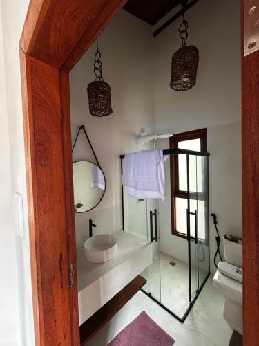 a bathroom with a sink and a mirror and a toilet at Vila Saquaira in Marau