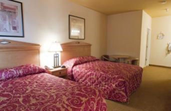 Habitación de hotel con 2 camas con colchas rojas en Garden Inn Hotel, en Union City