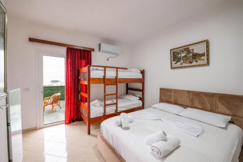 a bedroom with a bed and a bunk bed at Vila Myrtaj in Ksamil