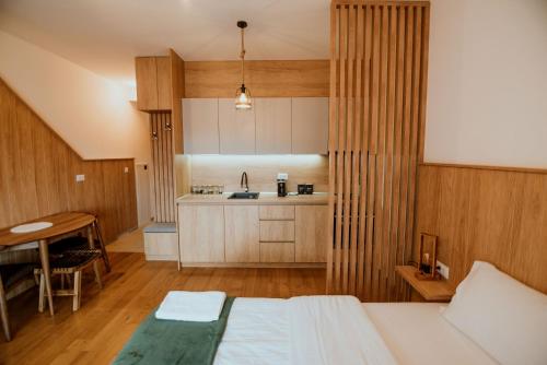 a bedroom with a bed and a table and a kitchen at Apartment Vila Jela in Kolašin