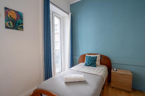 a small bed in a room with a window at Madeirarooms in Funchal