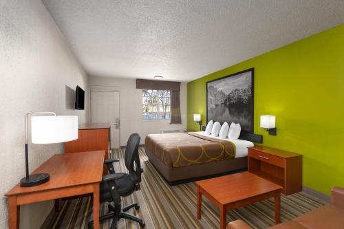 a hotel room with a bed and a desk and a desk at Super 8 by Wyndham Lake City in Lake City