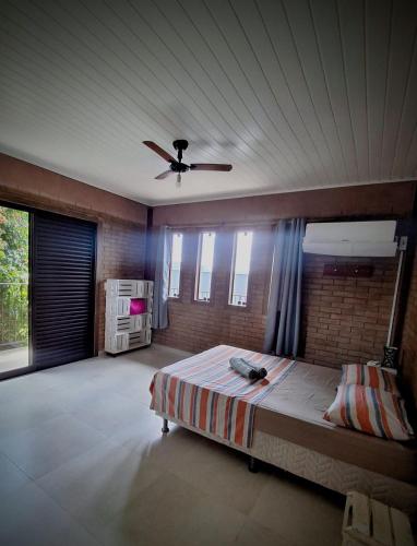 a bedroom with a bed and a ceiling fan at Morada das Flores in Palhoça