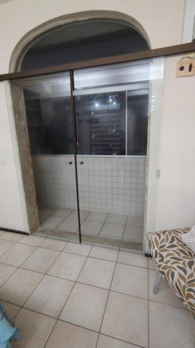 a bathroom with glass doors in a room with tile floors at Flat Olinda 4 Rodas in Olinda