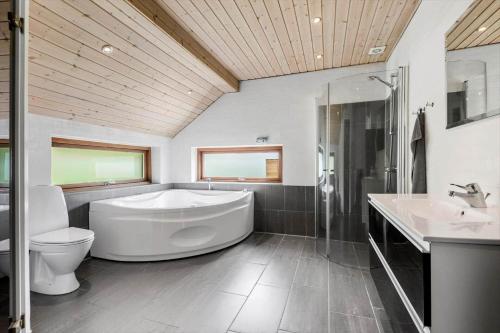a bathroom with a tub and a toilet and a sink at FAN032-Fano-Skovly-4 in Fanø