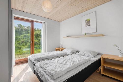 a bedroom with two beds and a large window at FAN032-Fano-Skovly-4 in Fanø