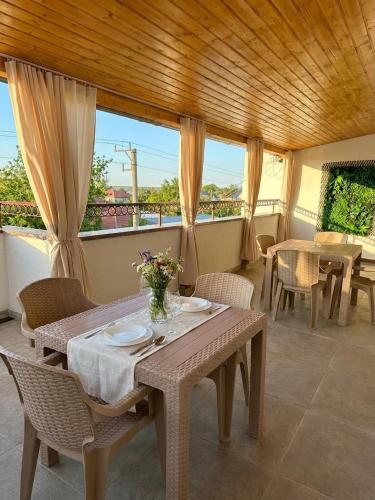 a dining room with tables and chairs and windows at Serenity Apartments and Studios in Eforie Nord