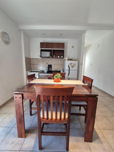 a kitchen with a wooden dining table and chairs at Departamento confortable con muy buena ubicacion y cochera para 4 personas in Corrientes