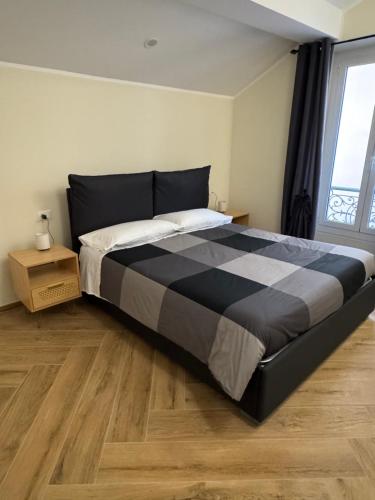 a large bed in a bedroom with a wooden floor at La Casa di Vale in Ventimiglia
