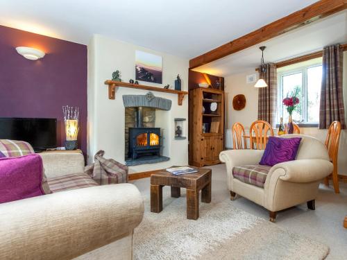 a living room with two couches and a fireplace at Yr Hen Felin in Mathry