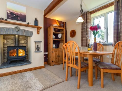 a living room with a table and a fireplace at Yr Hen Felin in Mathry
