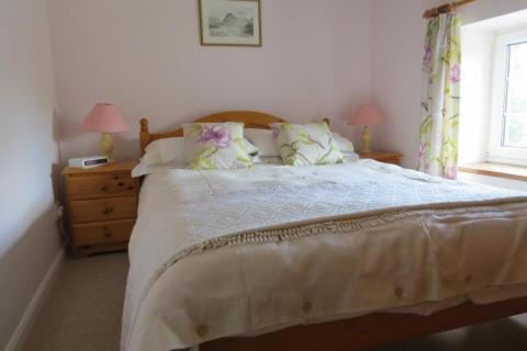a bedroom with a bed and a window at Garries Cottage in Bassenthwaite