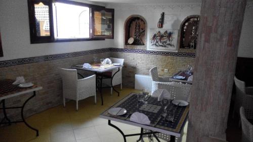 a restaurant with tables and chairs in a room at Pasta Plaza in Asilah