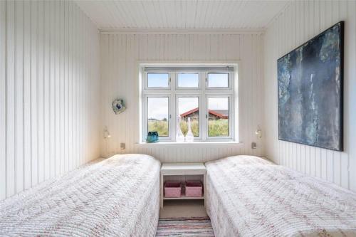 two beds in a white room with a window at 085-Ringkobing-Nordsovej-68 in Søndervig