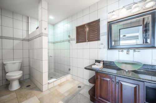 a bathroom with a sink and a toilet and a mirror at Corona del Mar #6 in Ocotal