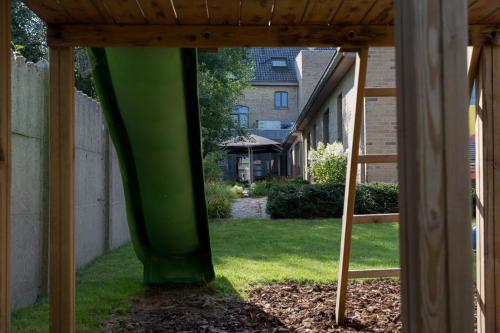 a green gazebo in a yard with a house at Oud Gemeentehuis in Poelkapelle