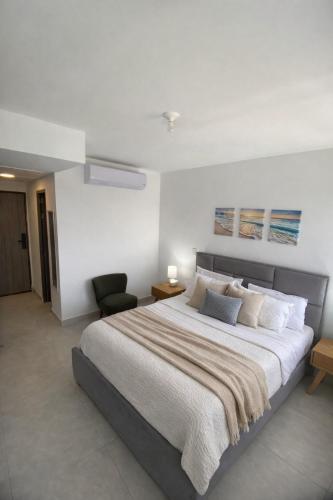 a bedroom with a large bed and a chair at Golden Breeze in Cartagena de Indias